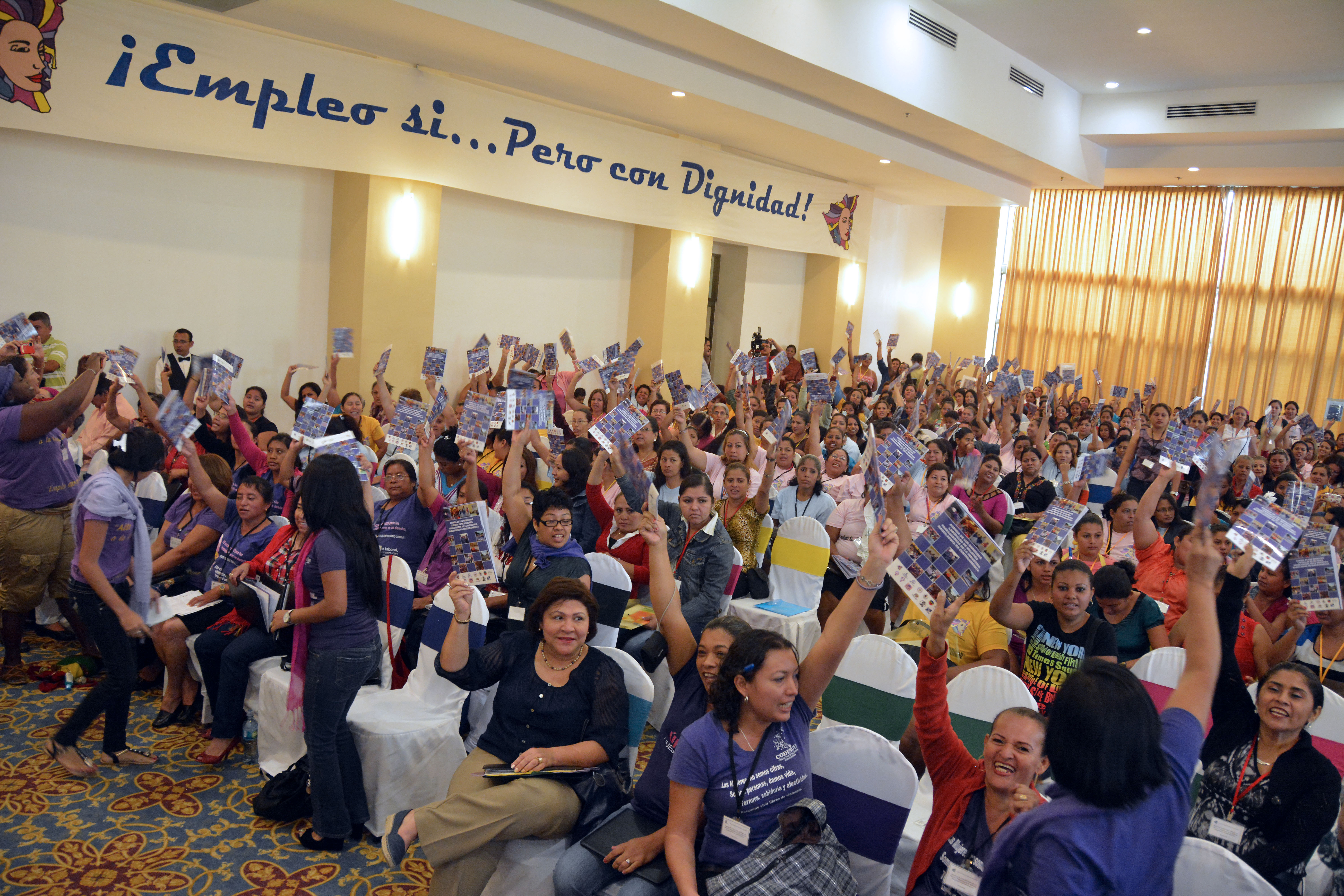 Room full of maquila workers, raising their hands to vote