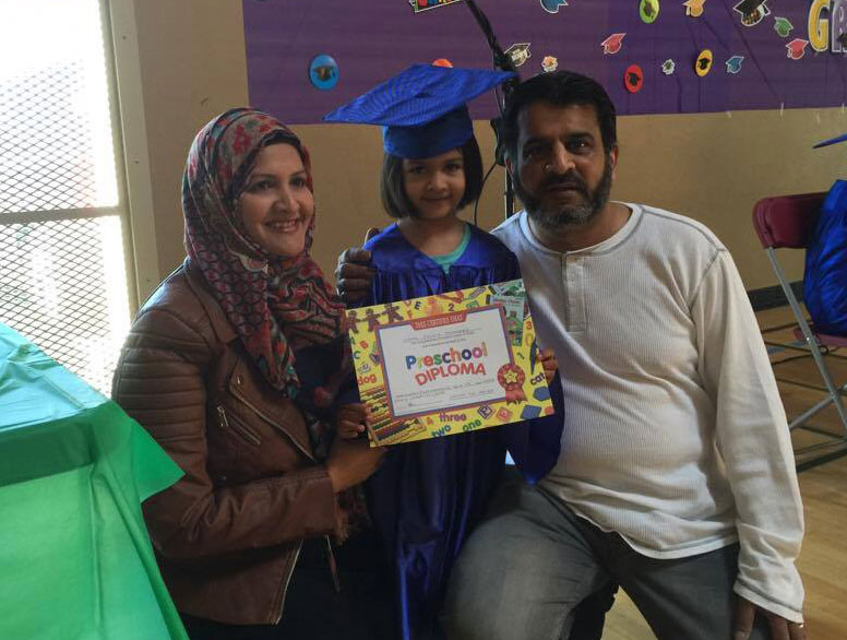 Woman, child, and man celebrating kindergarten graduation