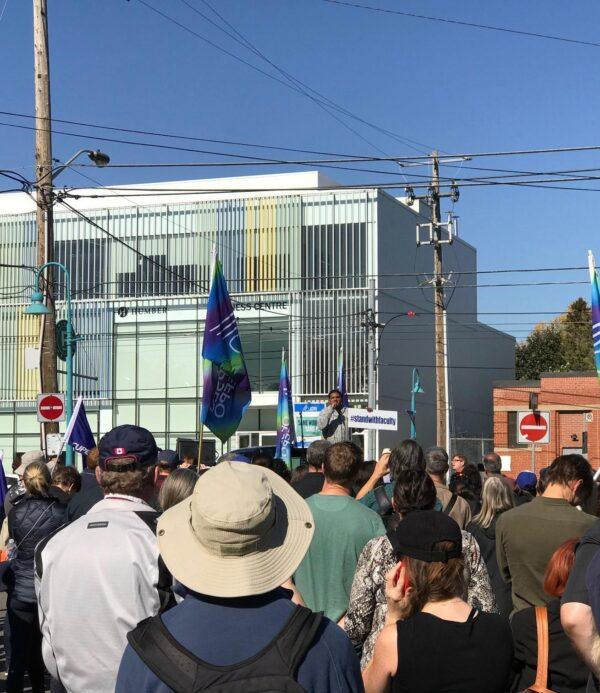 Group gathered in solidarity. Speaker has sign #standwithfaculty.