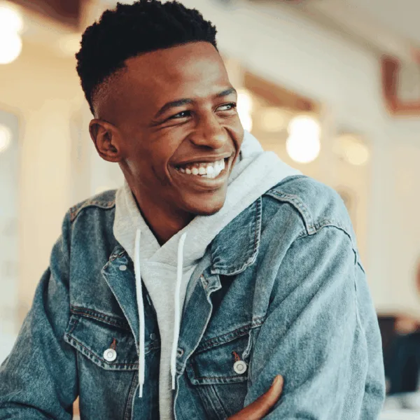 Text "Unlock" and image of smiling young man with short hair brown skin looking optimistic