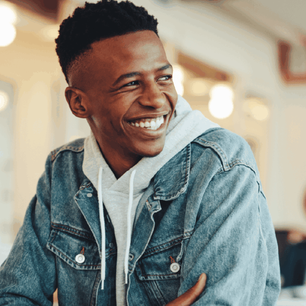 Text "Unlock" and image of smiling young man with short hair brown skin looking optimistic