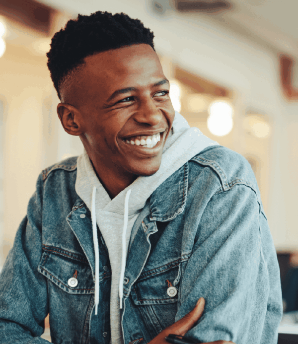 Text "Unlock" and image of smiling young man with short hair brown skin looking optimistic