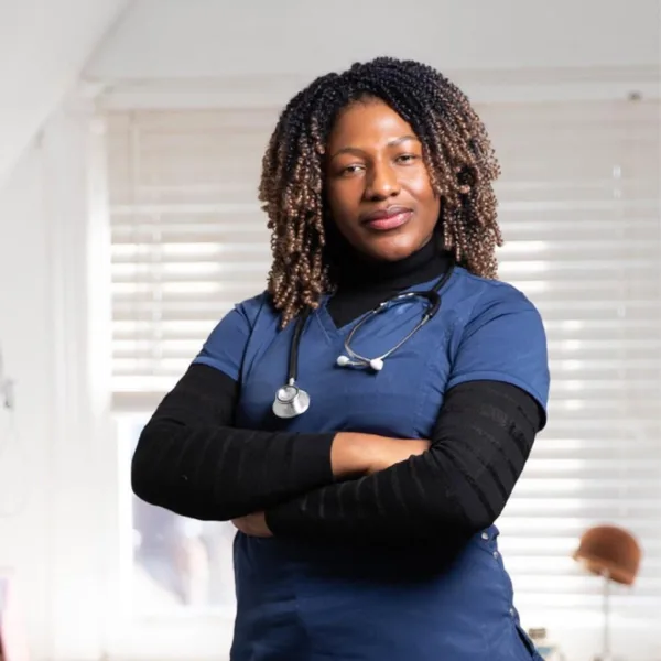 Woman, doctor with stethoscope with brown skin and tight curls standing with arms crossed