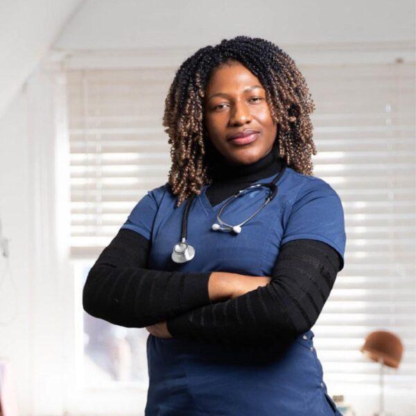Woman, doctor with stethoscope with brown skin and tight curls standing with arms crossed