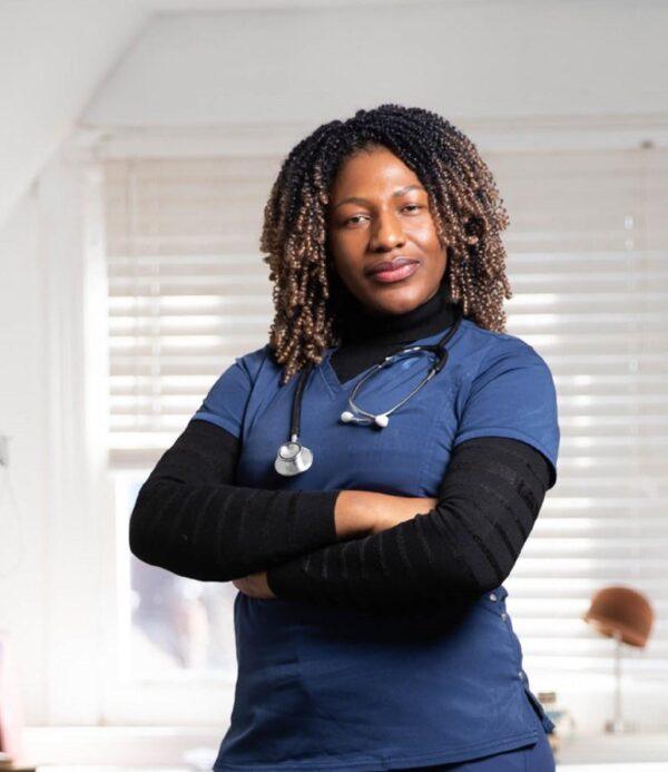 Woman, doctor with stethoscope with brown skin and tight curls standing with arms crossed